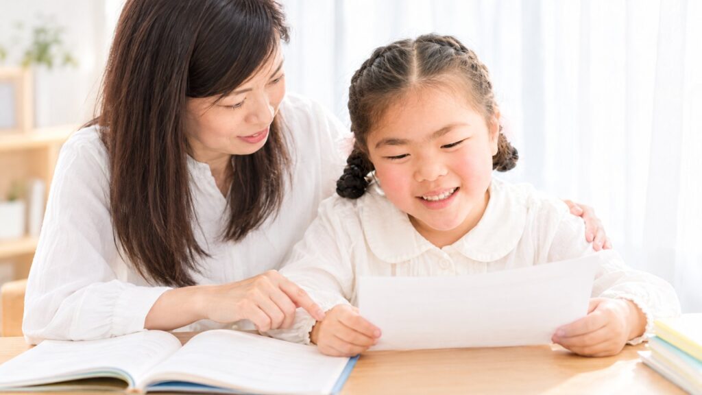 英検の成績表を見ながら子どもを励ますママ｜The English Home